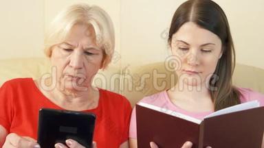 母女俩看电子书和实物打印书.. 纸张与数字阅读的概念